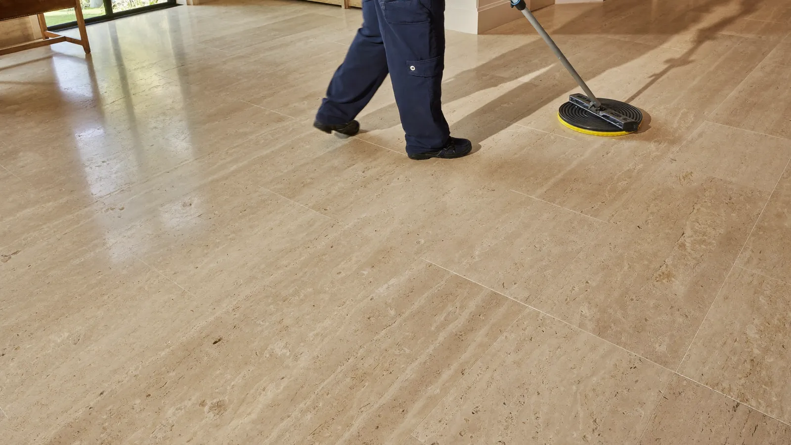 Specialist inspecting a travertine floor before treatment in London