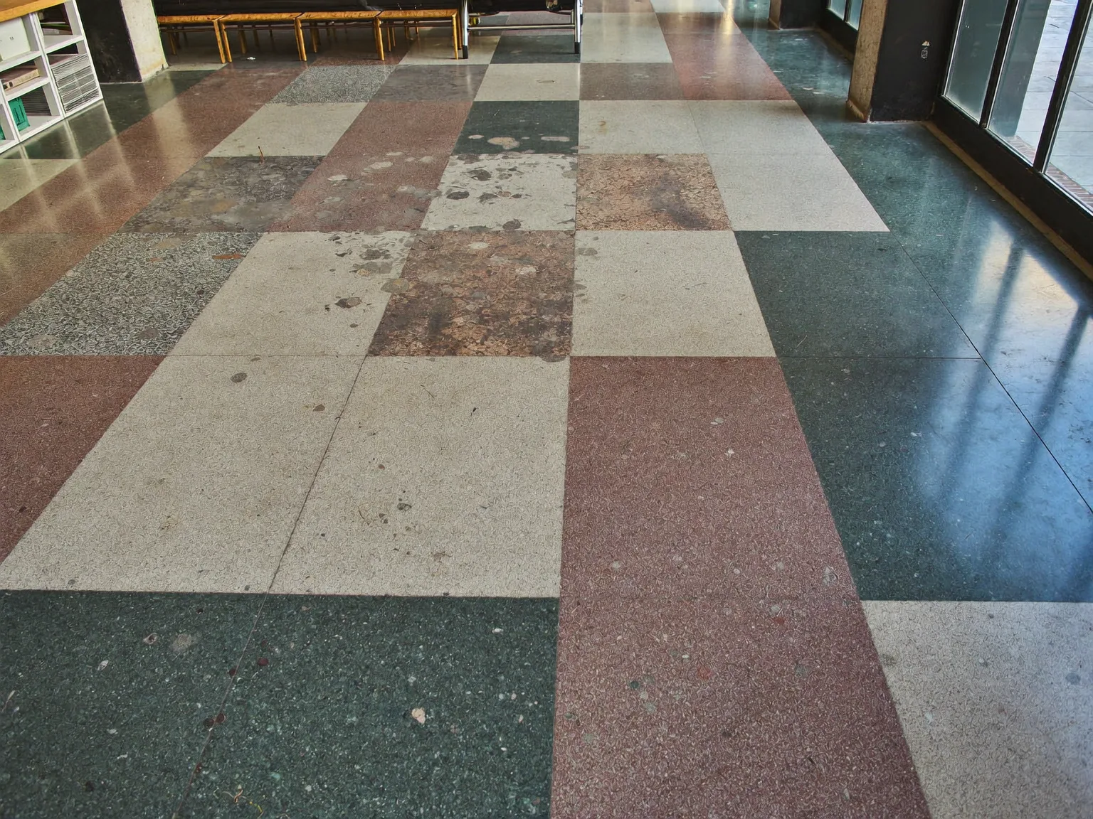 Worn terrazzo floor in a London commercial building before specialist restoration and sealing