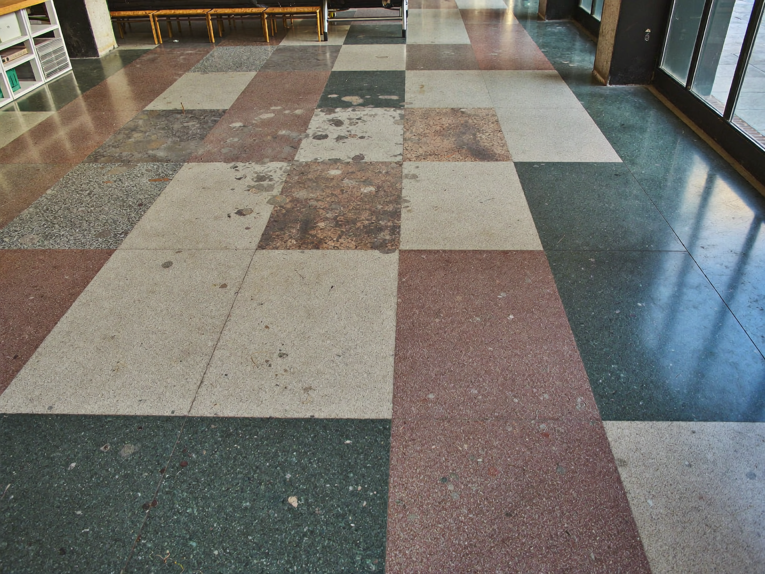 Worn terrazzo floor in a London commercial building before specialist restoration and sealing